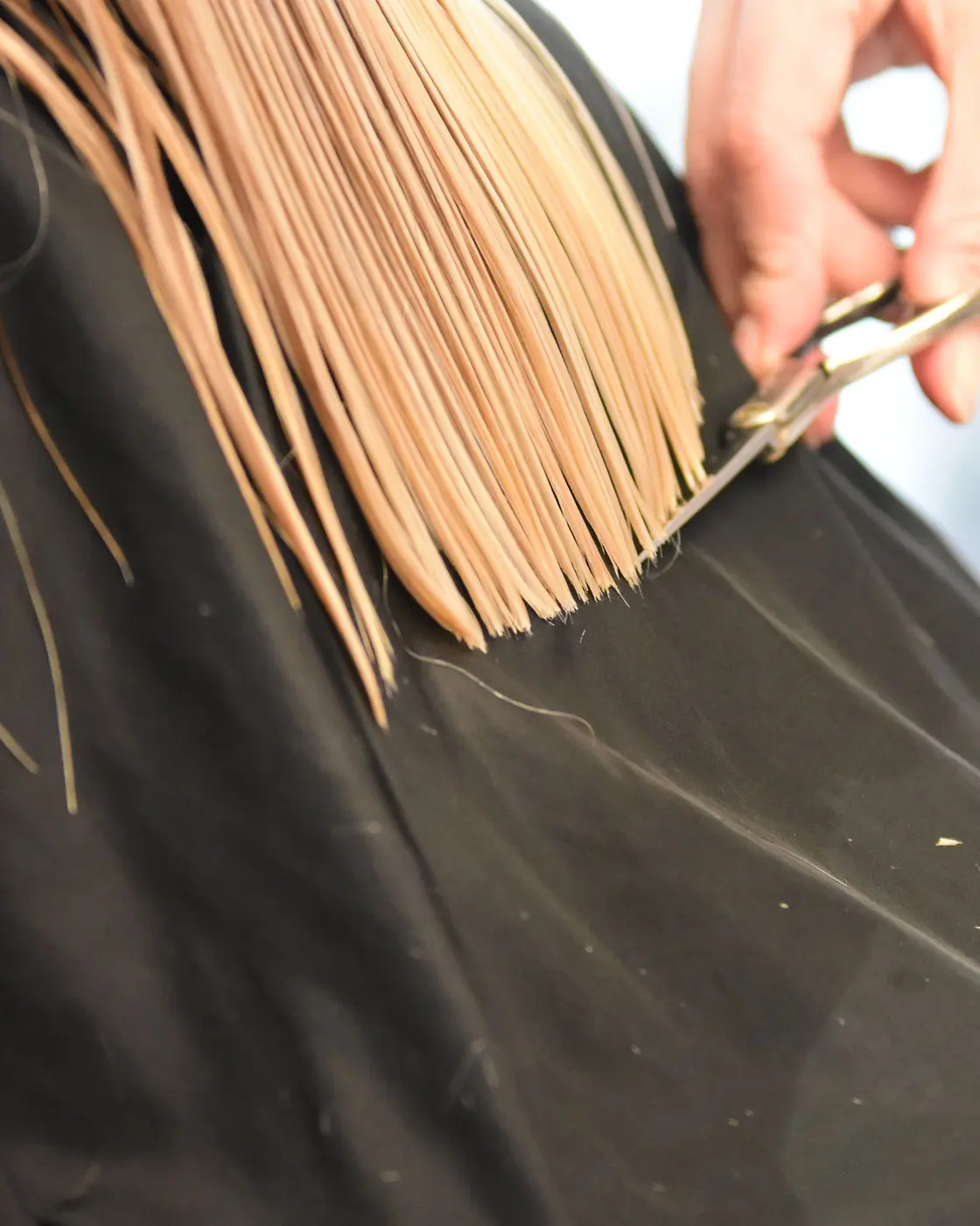 Une coupe en cours, ciseaux au-dessus d'une cape noire