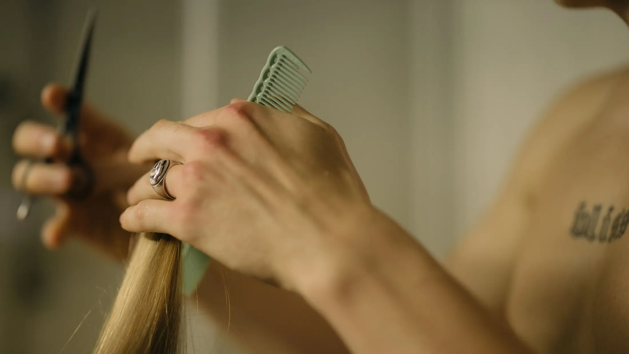 Mèche blonde tenue entre ciseaux et peigne